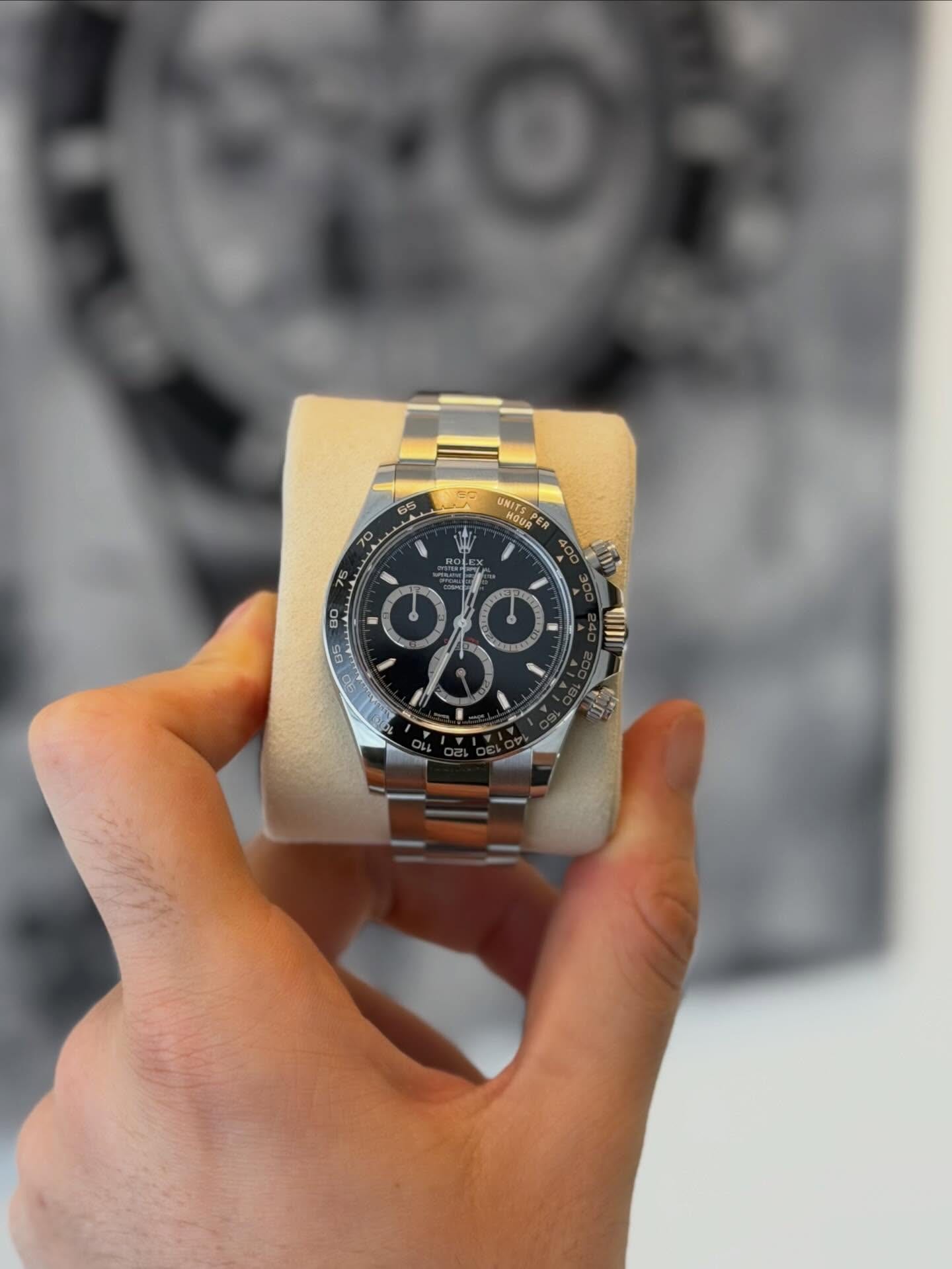 A Rolex Daytona chronograph resting on a display cushion