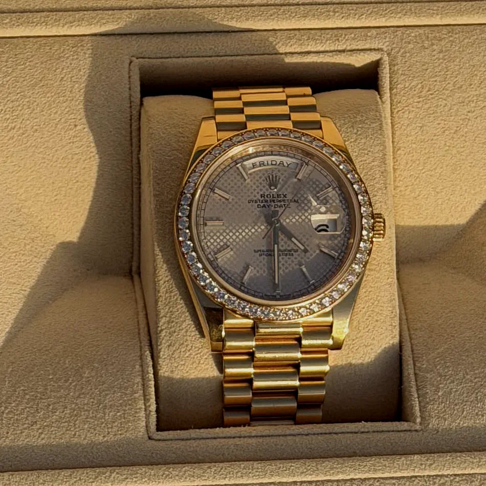 A yellow gold Rolex Day-Date with a diamond-set bezel on a President bracelet, presented in its Rolex box